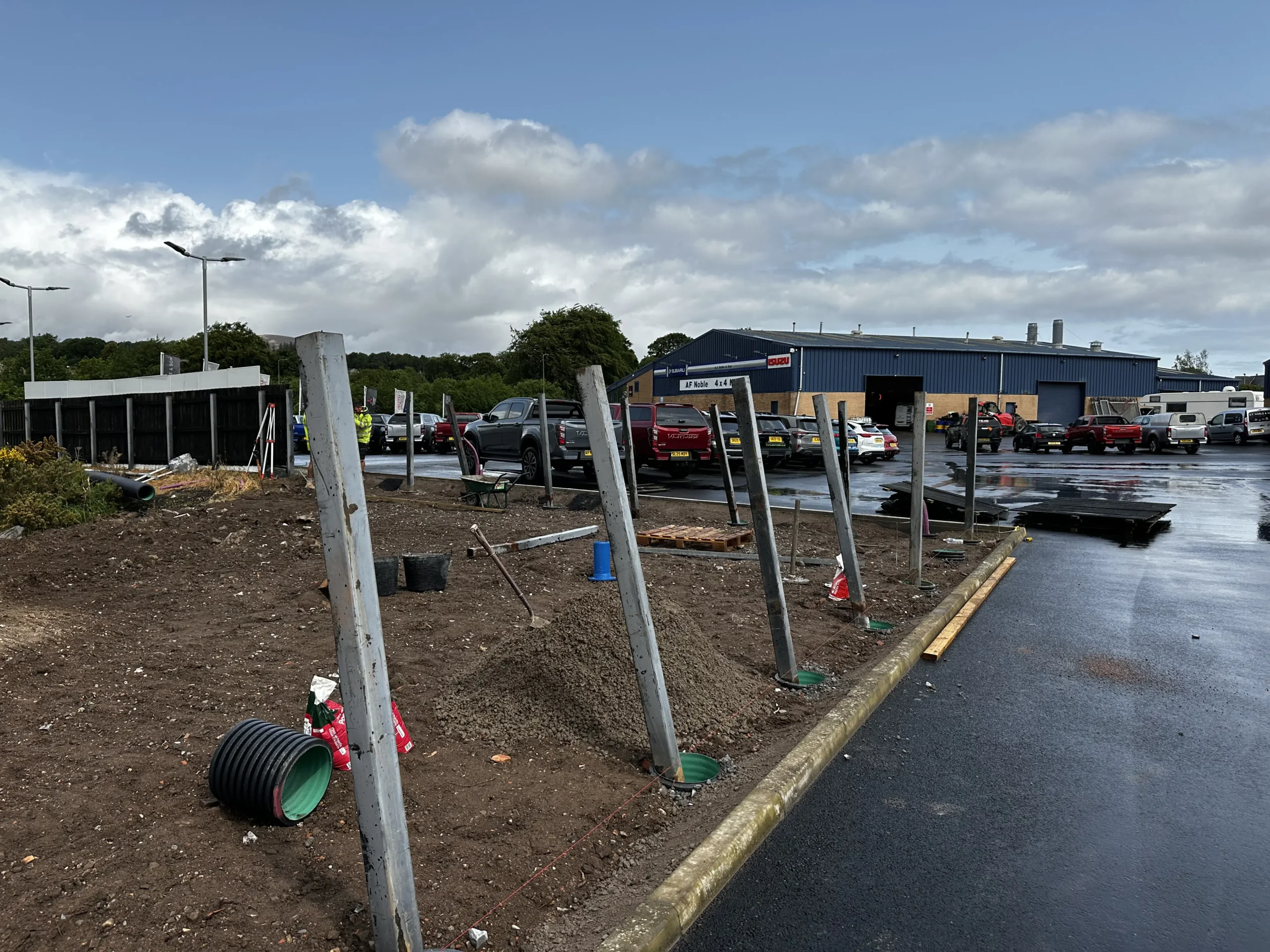 A parking lot filled with dirt and several poles scattered throughout the area